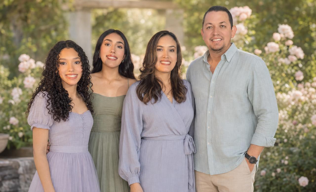 Fernanda junto a su familia en un jardín de tonos pastel